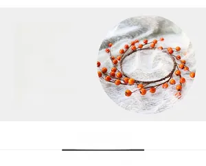 Detail of orange berry wreath with faux plastic berries and brown twig base decor