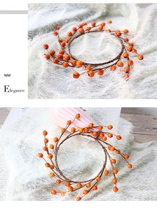 Detail of autumn orange berry wreath featuring realistic wood-textured vine and glossy berries
