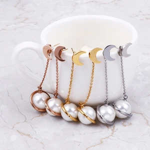 Boucles d'oreilles étoile et perle en or, argent et rose doré sur tasse en céramique
