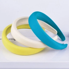 Dettaglio di cerchietti in spugna spessa nei colori giallo, beige e blu pavone