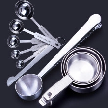 Detailed set of silver stainless steel measuring spoons and cups with engraved metrics