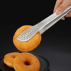 Pince alimentaire en acier inoxydable 304 saisissant un donut sur fond noir