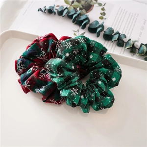 Close-up of red and green plaid Christmas scrunchies with white snowflake patterns