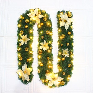2.7m artificial Christmas garland with gold flowers and warm LED lights on a white wall
