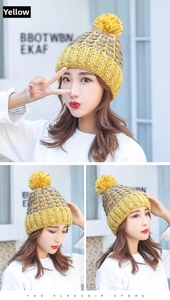 Vista dettagliata del berretto in maglia da donna con pompon e design giallo e grigio