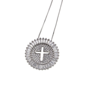 Macro shot of a round silver pendant necklace featuring a hollow cross with zircon stones