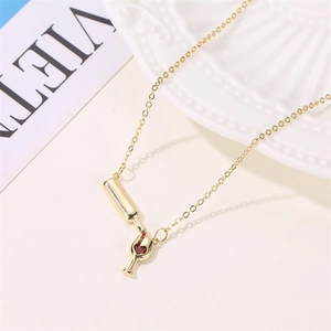 Creative gold wine bottle and glass necklace with heart crystals on fashion magazine