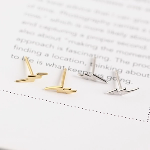 Detailed view of minimalist S925 sterling silver lightning bolt studs in gold and silver