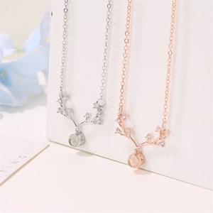 Detail of silver and rose gold reindeer antler necklaces with 100 languages projection stone