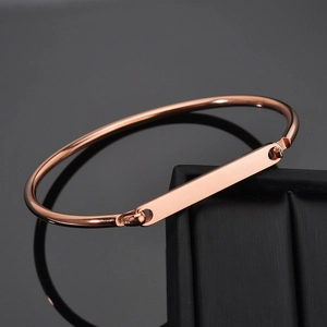 Macro shot of rose gold plated C-shape cuff bracelet with a polished rectangular metal plate