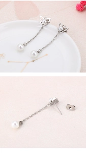 Details von französischen Quastenohrringen mit Schmetterlingsstecker und Perle