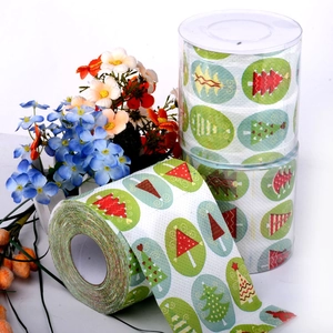 Detail of Christmas tree patterned toilet paper rolls in clear cylindrical packaging