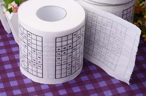 Detail of toilet paper roll featuring printed Sudoku puzzles with numbers on white paper
