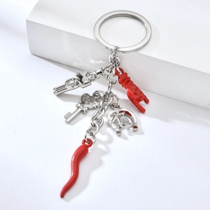 Detail of metal keychain with red chili horn, lucky number 13 horse shoe and hot key charms