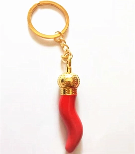 Detail of red cornicello lucky charm keychain with golden crown cap and metal ring