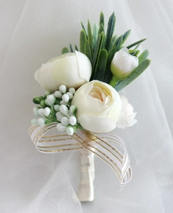 Detail of cream roses wedding boutonniere with satin ribbon and gold-striped organza bow