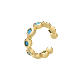 Macro shot of gold-plated ear cuff with micro-pave inlaid turquoise blue gemstones