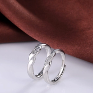 Intertwined silver couple rings with cubic zirconia and polished metallic finish