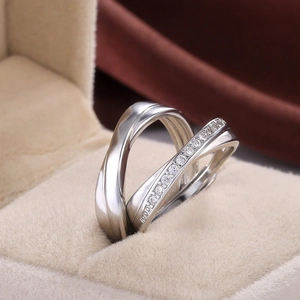 Minimalist silver wave rings for couples with zircons in a beige jewelry box