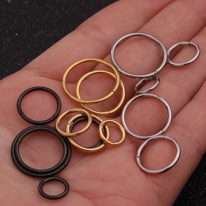 Minimalist stainless steel nose and ear rings in black gold and silver on palm