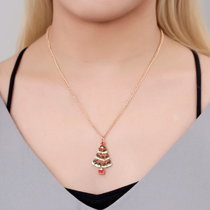 Détail d'un collier doré avec un pendentif sapin de Noël coloré porté par un mannequin