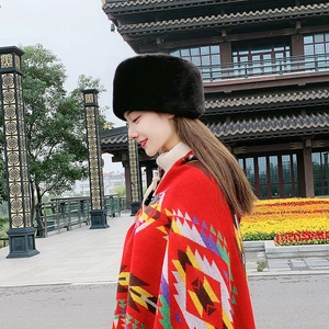 Detail of warm black faux fur hat and red patterned shawl worn by elderly woman