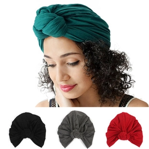Détail des turbans à nœud colorés montrant la texture douce du tissu et la coupe