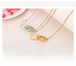 Detail view of heart and paw print pendant necklaces in silver and gold finishes