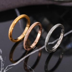 Three matte titanium steel rings in gold, rose gold and silver on black marble