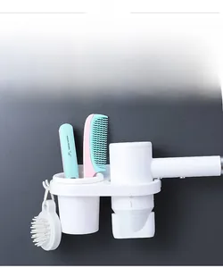 Wall-mounted hair dryer holder with storage cup and hooks on grey tile bathroom wall