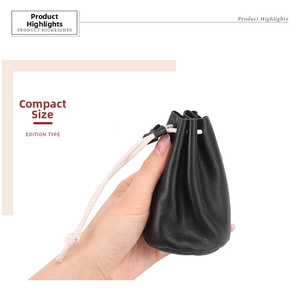 Detail showing hand holding a compact black leather drawstring coin and lipstick pouch