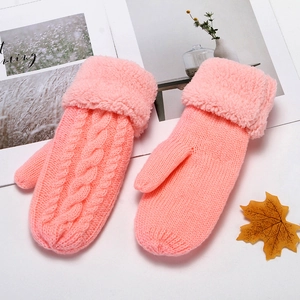 Detail of pink knitted mittens with cable pattern and thick plush faux fur lining