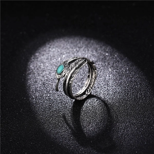 Anillo de pluma plateado estilo punk con piedra turquesa y textura metálica vintage