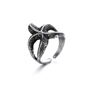Detalle del anillo con forma de estrella de mar con acabado y textura de plata vieja