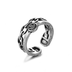 Primer plano del anillo punk vintage con cara sonriente y detalles de eslabones de cadena