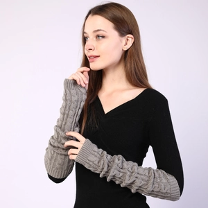 Detailed cable knit texture of long grey arm warmers made of thick thermal wool yarn