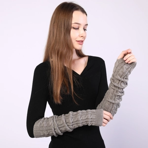 Close-up of grey cable-knit long arm warmers showing thick textured wool material