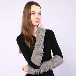 Close-up of grey cable-knit arm warmers showing texture and thick knitted pattern
