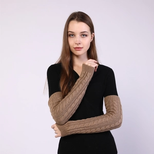 Close-up of brown knit cable arm warmers worn over a black long-sleeve shirt