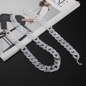 Close-up of white marble acrylic glasses chain with non-slip silicone loops on fashion magazine