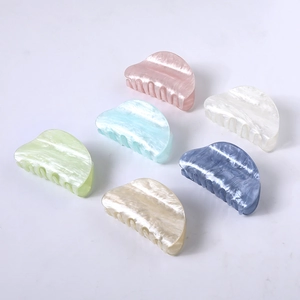 Detailed grid of colorful acetate shark hair claws with elegant marble texture