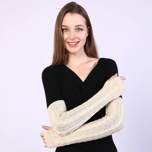 Close-up of cream knit arm warmers with cable knit pattern on a model arms