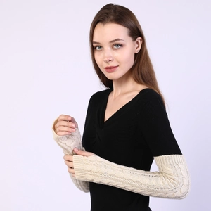 Detail view of beige cable knit arm warmers showing the textured pattern and long fit