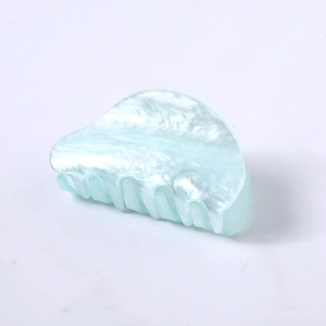 Detail view of mint blue acetate hair claw clip with marble texture and pearl finish