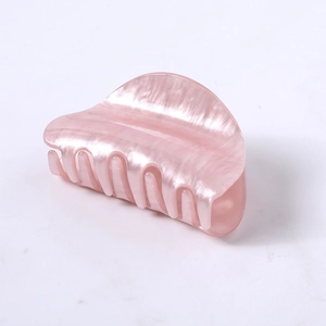 Close-up of a large pearlescent pink claw clip with smooth acetic acid texture finish