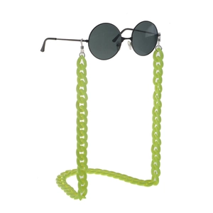 Detail of neon green acrylic chunky chain strap attached to vintage black round sunglasses
