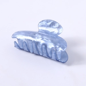 Macro detail of large light blue marble pattern acetate claw clip hair accessory