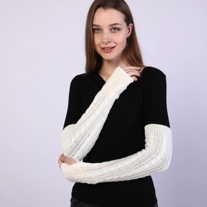 Close-up of cream knit cable long fingerless gloves showing thick texture and thumb hole