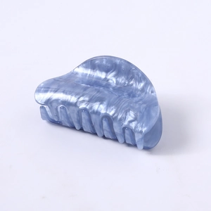 Close-up of light blue marble textured hair claw clip with glossy pearlescent finish