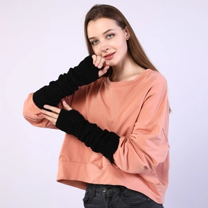 Detail of black knitted cable long arm warmer showing ribbed cuffs and soft texture